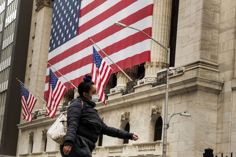 A pedestrian with a mask walks past of the New York Stock Exchange (NYSE) as markets continue to react to the coronavirus disease (COVID-19) at the NYSE in New York, U.S., March 18, 2020. REUTERS/Lucas Jackson